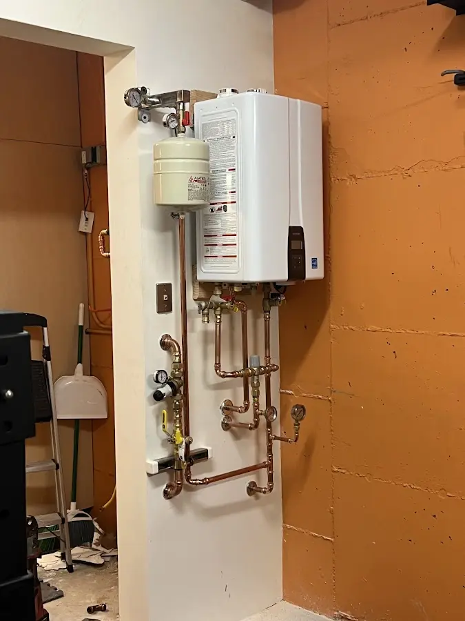 Plumbing technician inspecting water heater connections in Jeffersontown